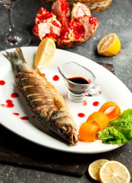 side-view-baked-sea-bass-served-with-lemonnd-narsharab-sauce-white-platter-black_140725-11837 side-view-baked-sea-bass-served-with-lemonnd-narsharab-sauce-white-platter-black_140725-11837